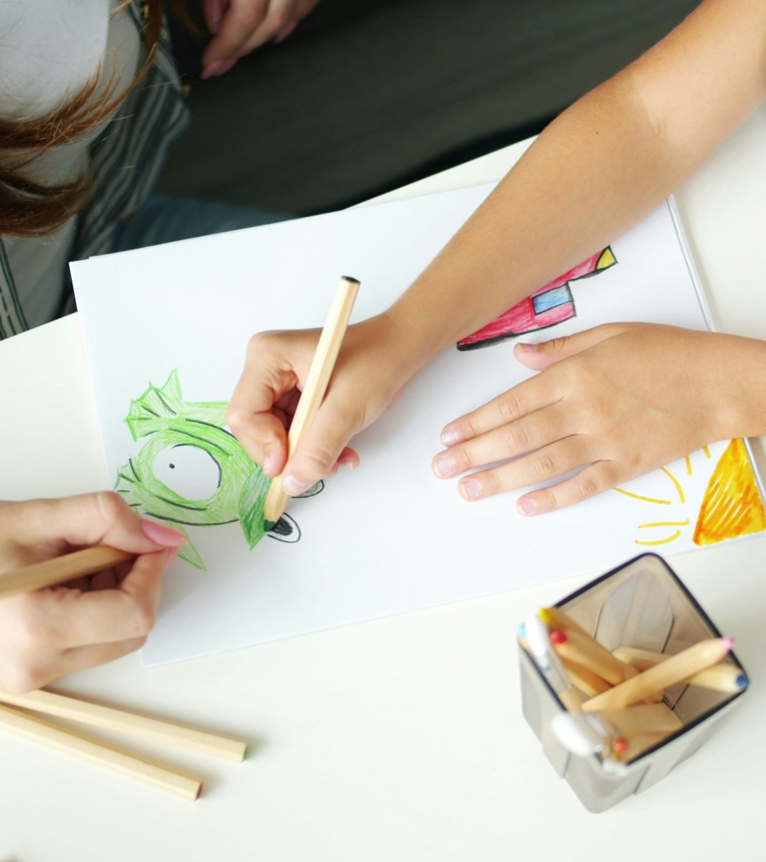 Adulto e criança desenhando juntos na Clínica Nascente